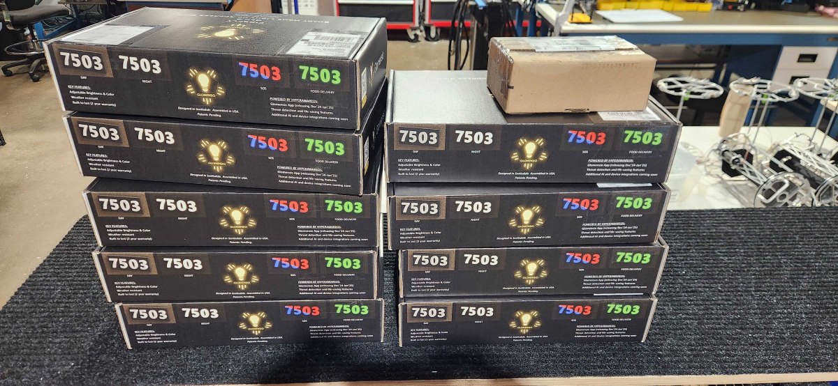 Glomensio Firefly illuminated house numbers — bulk shipment of individually packaged units stacked and ready for builder deployment