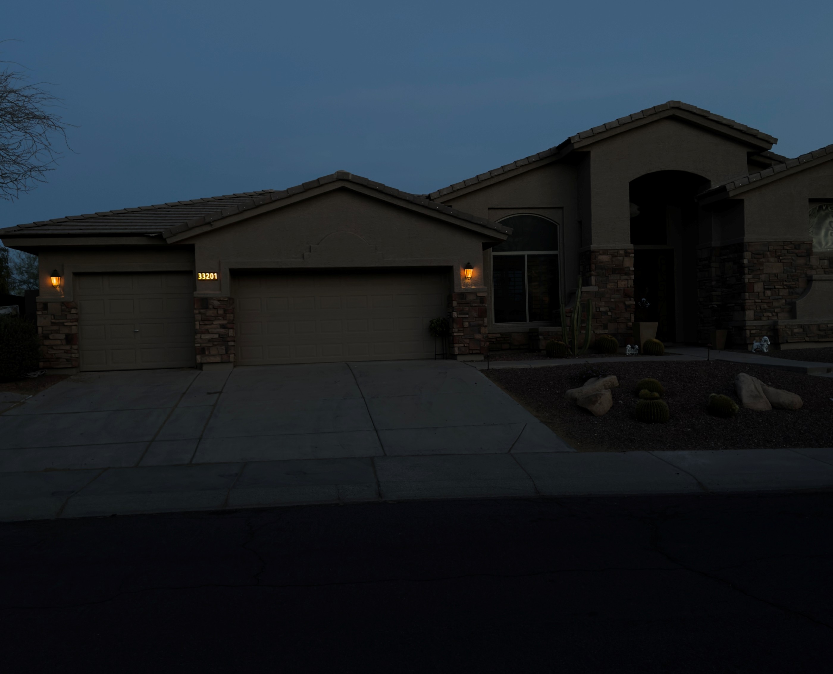 Glomensio Firefly illuminated house number sign installed on a luxury suburban home at dusk