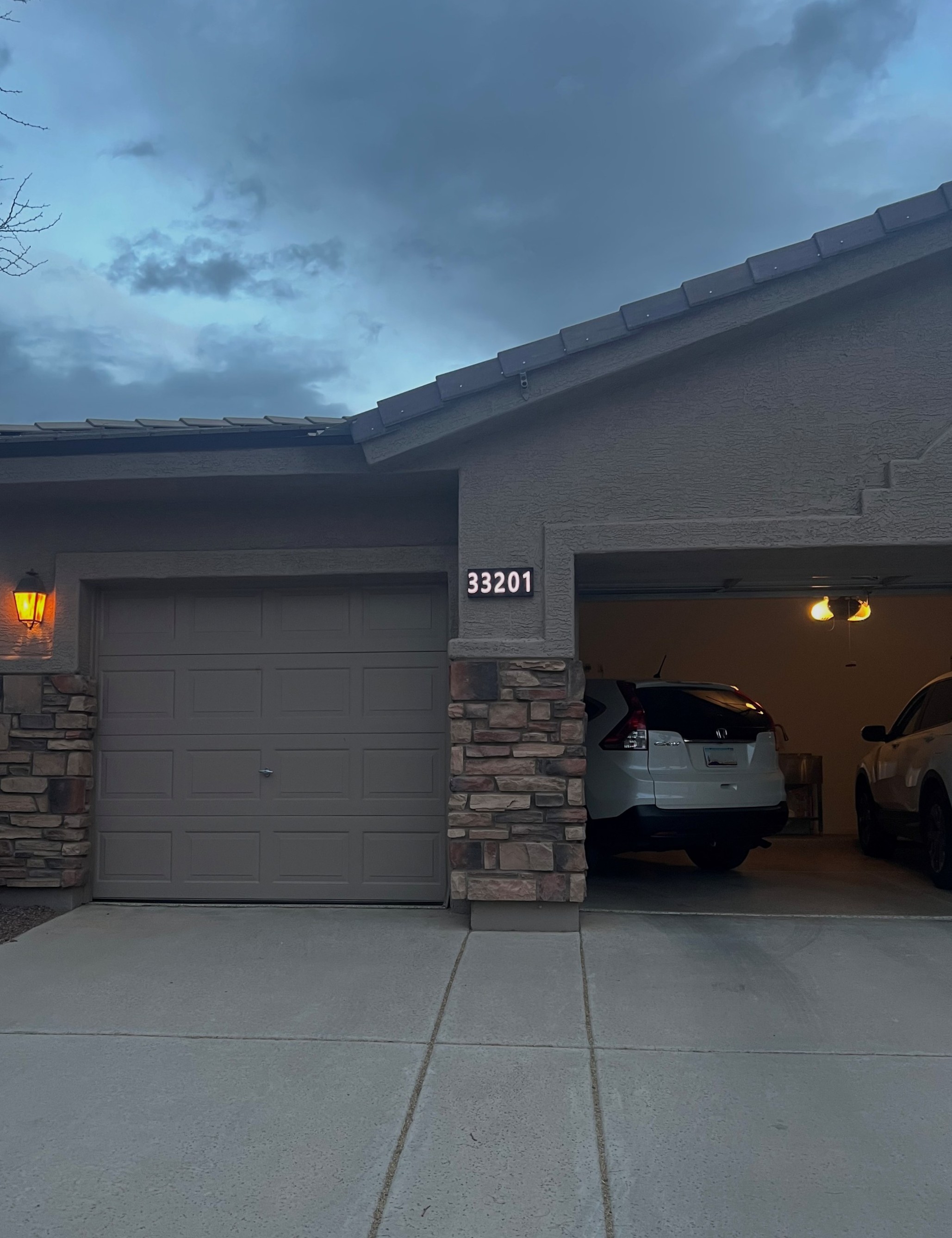 Glomensio Firefly illuminated house number 33201 installed on a suburban home at dusk — the product you'll be installing